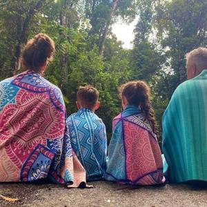 family of four with evolve sand free towels sitting with back to camera